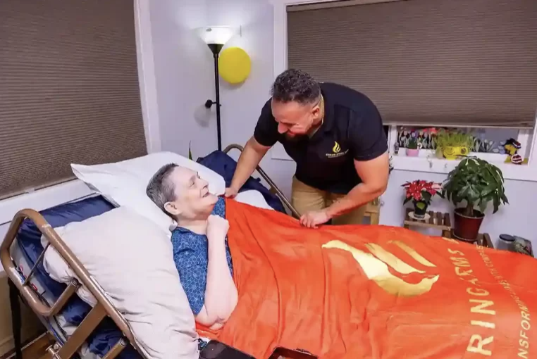 Caregiver attending to resident in bed